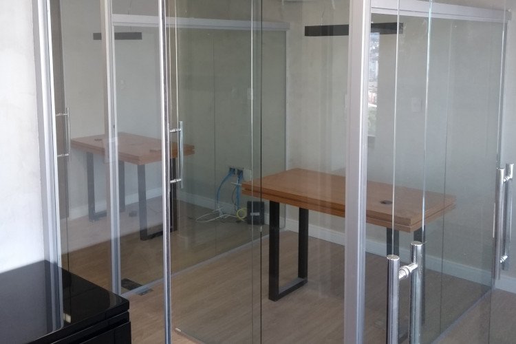 Sala com divisória de vidro e porta integrada